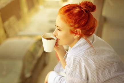 good morning womans with cup of fragrant coffee on balcony